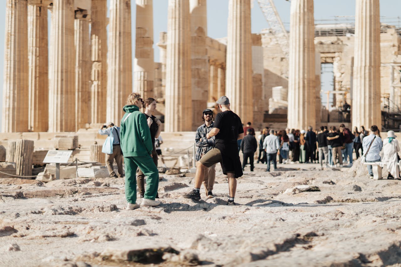 A group of tourists exploring the ancient ruins of the Parthenon in Athens, Greece.
